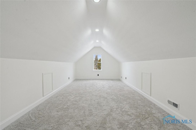 bonus room with light carpet and lofted ceiling