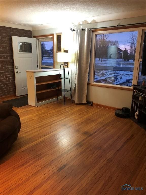 interior space with brick wall and wood-type flooring