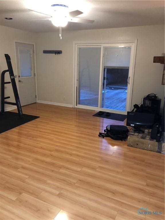 exercise room with ceiling fan and light hardwood / wood-style floors