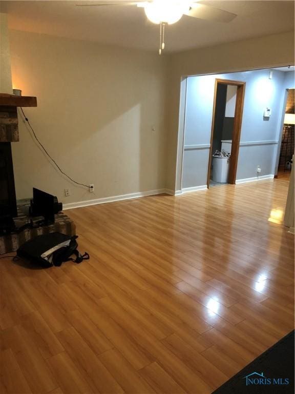 unfurnished living room featuring ceiling fan and light wood-type flooring