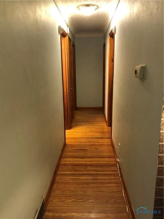 hallway with hardwood / wood-style flooring and crown molding