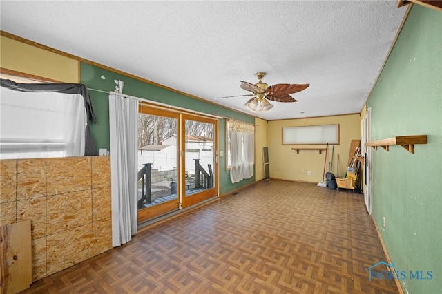 interior space featuring ceiling fan, a textured ceiling, and dark parquet floors