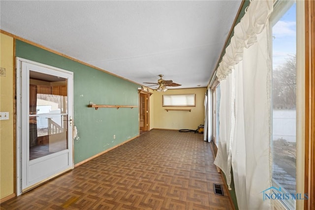 unfurnished room with ceiling fan and dark parquet flooring