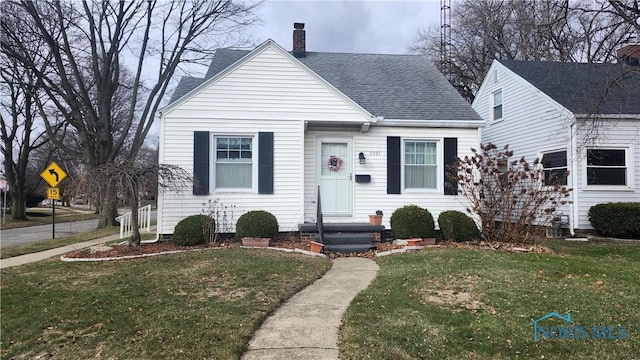 bungalow-style home featuring a front lawn