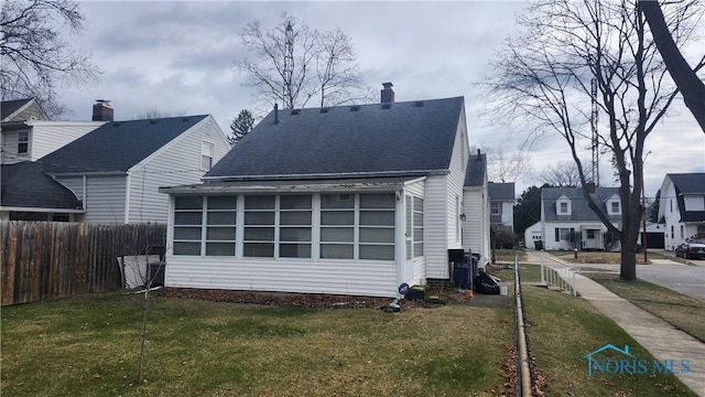 back of house featuring a sunroom and a yard