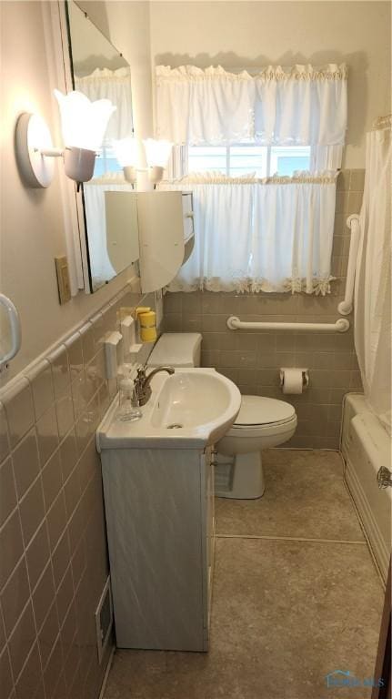 full bathroom featuring toilet, vanity, tile walls, tile patterned flooring, and shower / bath combo with shower curtain