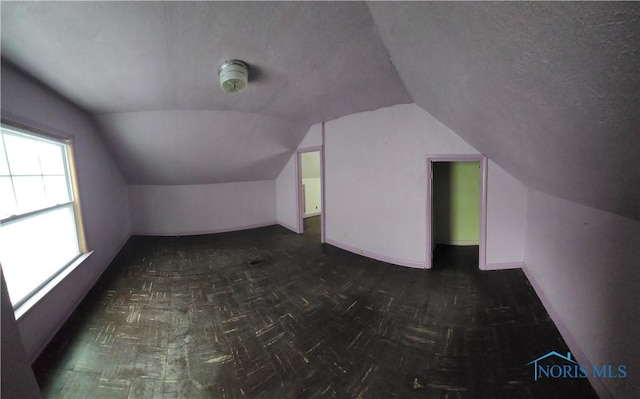 bonus room featuring a textured ceiling and vaulted ceiling