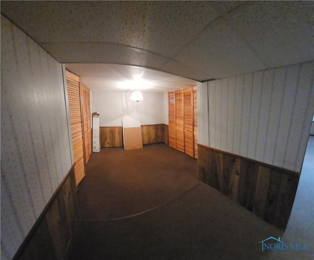 basement featuring a drop ceiling and carpet flooring