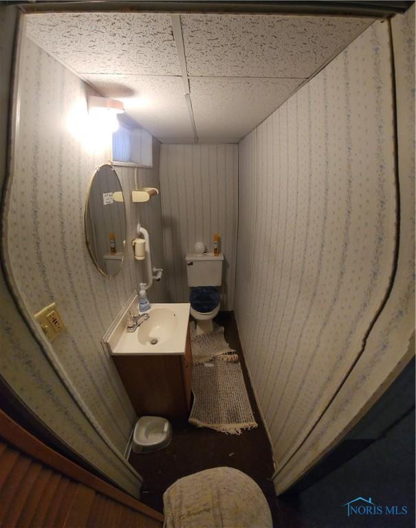 bathroom with toilet, a drop ceiling, and vanity