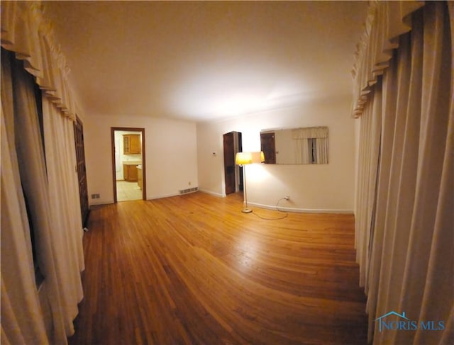 empty room with hardwood / wood-style flooring