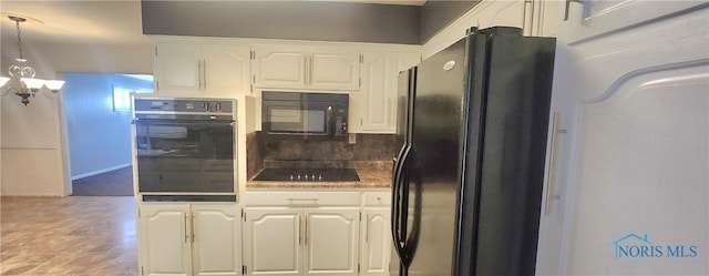 kitchen with decorative backsplash, white cabinetry, pendant lighting, and black appliances