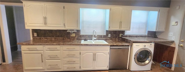 kitchen with sink, stainless steel dishwasher, tasteful backsplash, white cabinetry, and washer / clothes dryer