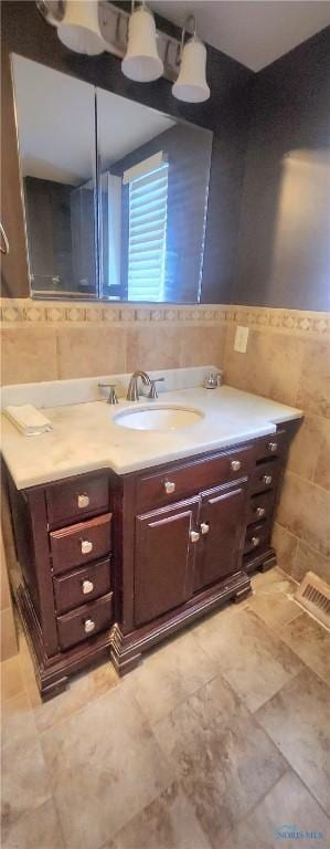 bathroom with vanity and tile walls