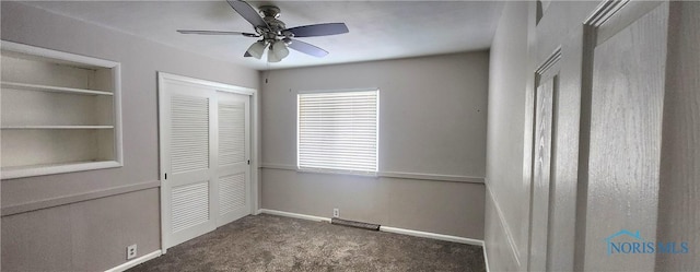 unfurnished bedroom with ceiling fan, dark carpet, and a closet