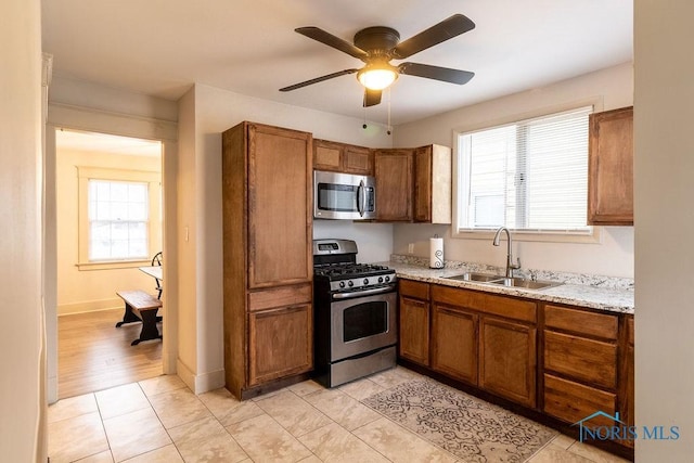 kitchen with ceiling fan, sink, light tile patterned flooring, and appliances with stainless steel finishes