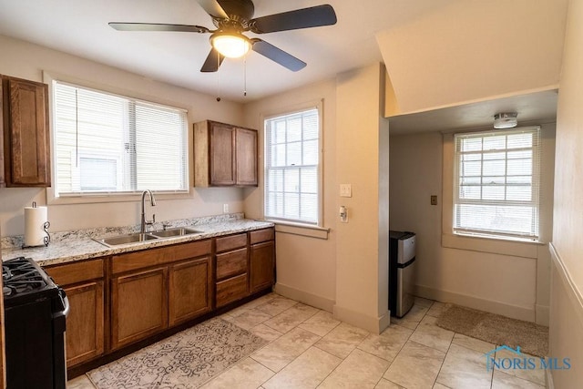 kitchen with light tile patterned flooring, black stove, ceiling fan, and sink