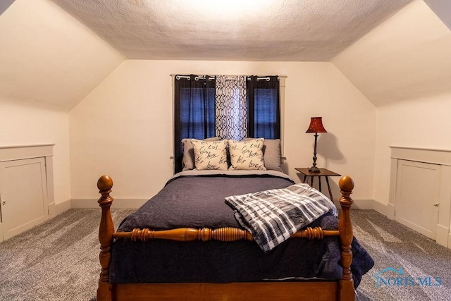 carpeted bedroom with a textured ceiling and vaulted ceiling