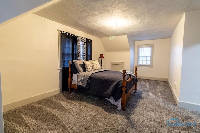 carpeted bedroom with a textured ceiling and lofted ceiling