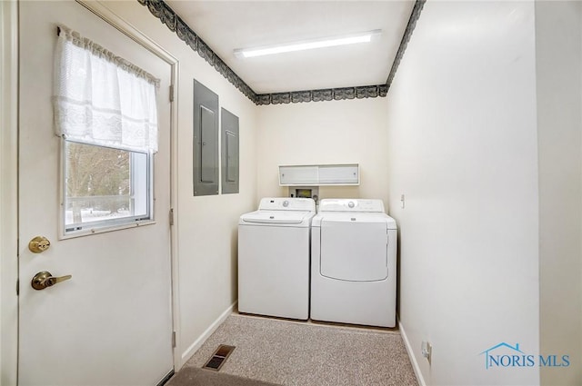 laundry area with electric panel, light carpet, and washer and dryer