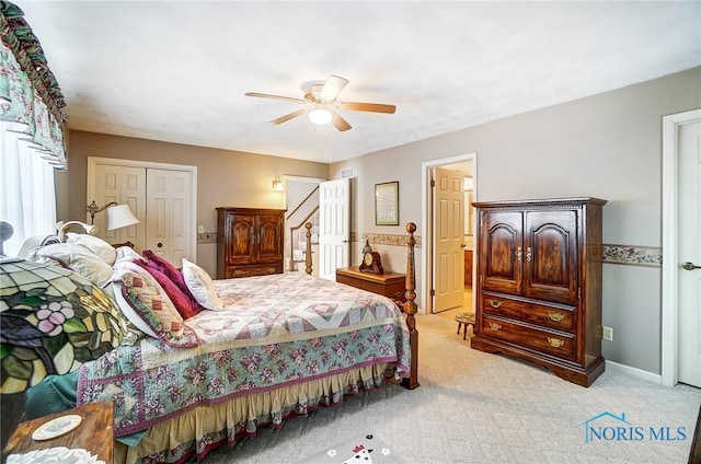 bedroom with ceiling fan, a closet, and light carpet