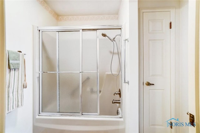 bathroom featuring combined bath / shower with glass door