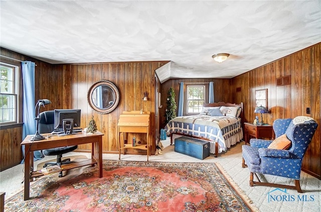 bedroom with multiple windows and wood walls