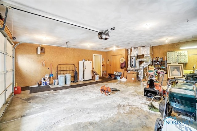 garage with white fridge and a garage door opener