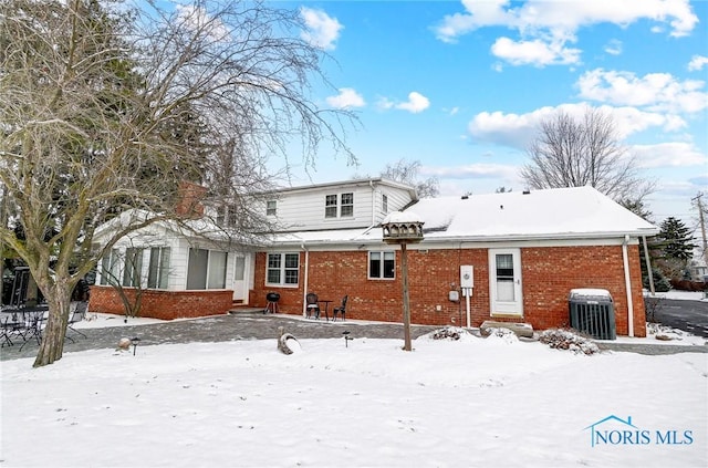 snow covered back of property with central air condition unit