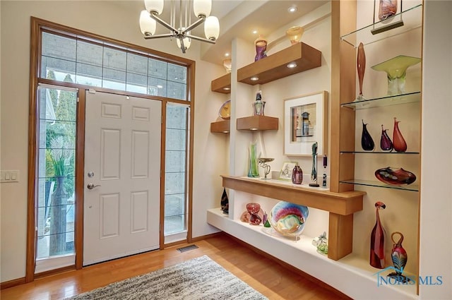 foyer entrance featuring hardwood / wood-style floors and a chandelier