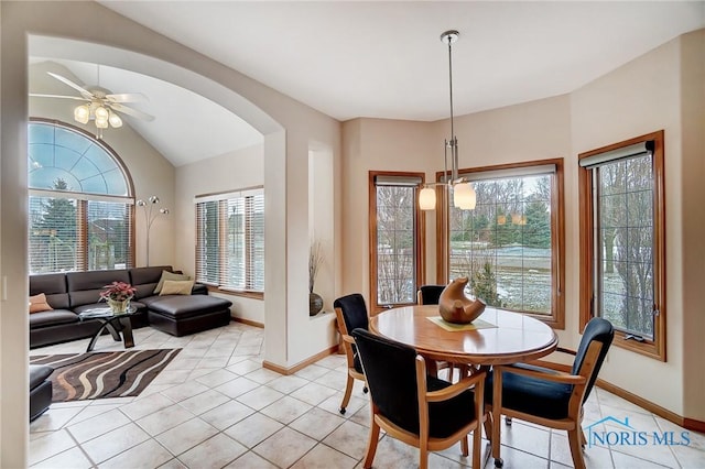 dining area featuring ceiling fan, plenty of natural light, light tile patterned floors, and vaulted ceiling