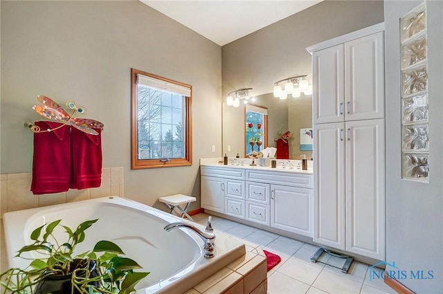 bathroom featuring tile patterned floors, vanity, and tiled tub