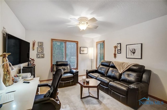 office space featuring ceiling fan, light colored carpet, and a textured ceiling