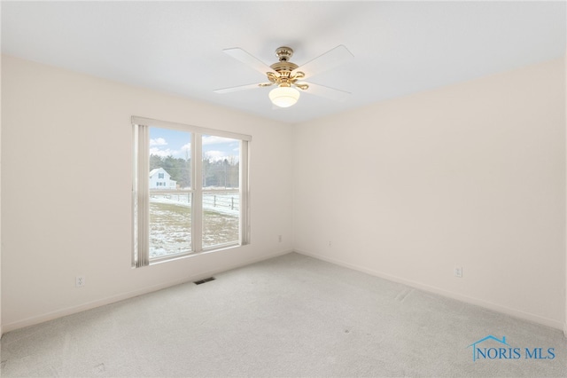 spare room featuring ceiling fan and carpet