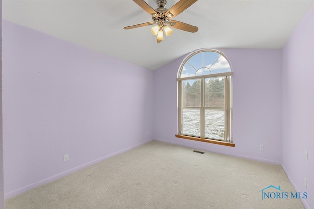 carpeted spare room with ceiling fan and vaulted ceiling