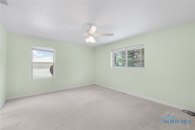 carpeted spare room with ceiling fan