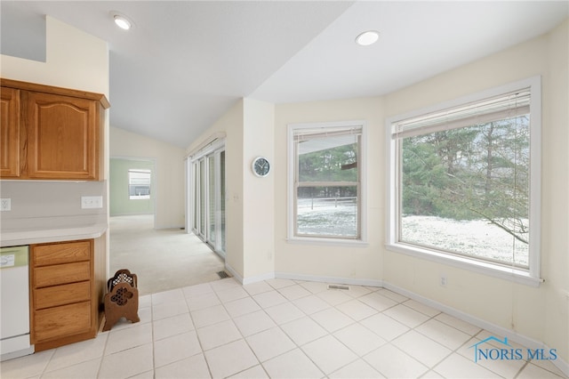 kitchen with light colored carpet, dishwasher, and lofted ceiling