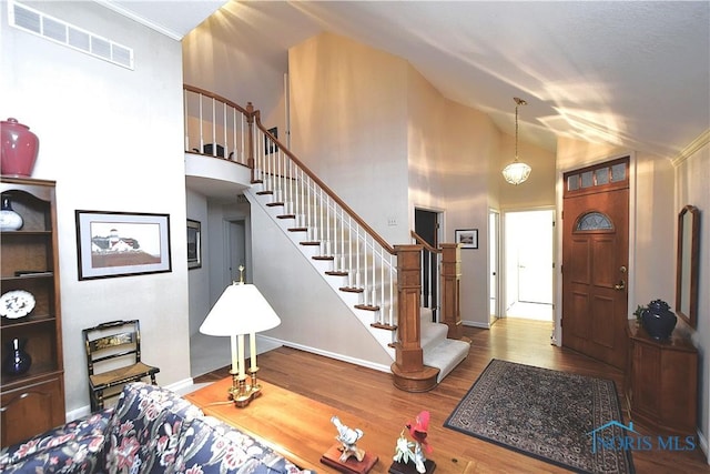 entryway with an inviting chandelier, hardwood / wood-style flooring, and high vaulted ceiling