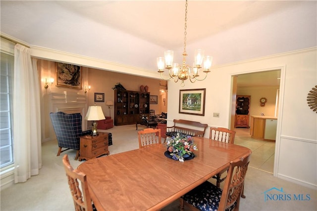 carpeted dining room with crown molding and a chandelier