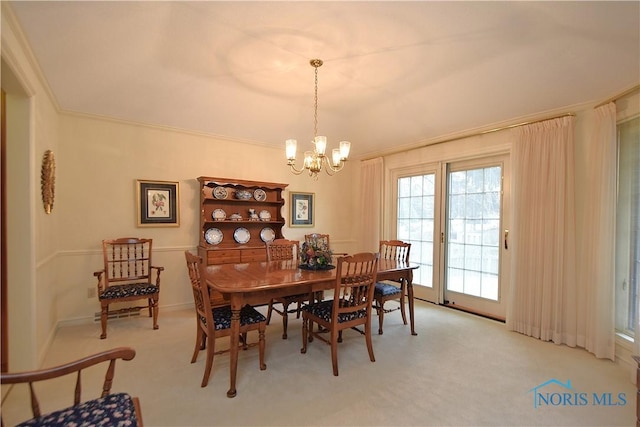 dining space with light colored carpet, ornamental molding, and an inviting chandelier