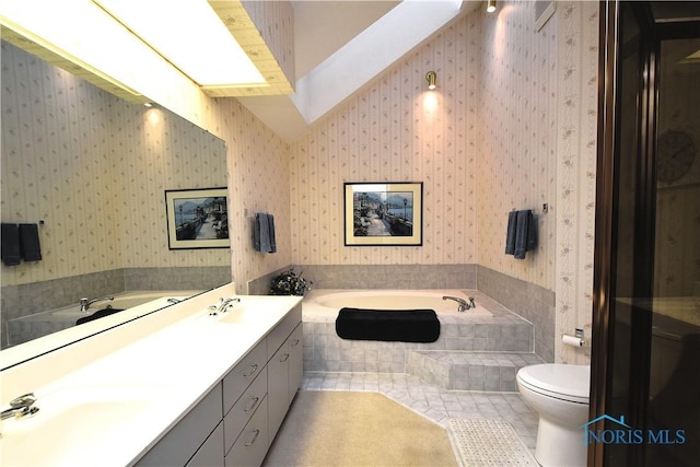 bathroom with tile patterned floors, tiled bath, vanity, and toilet