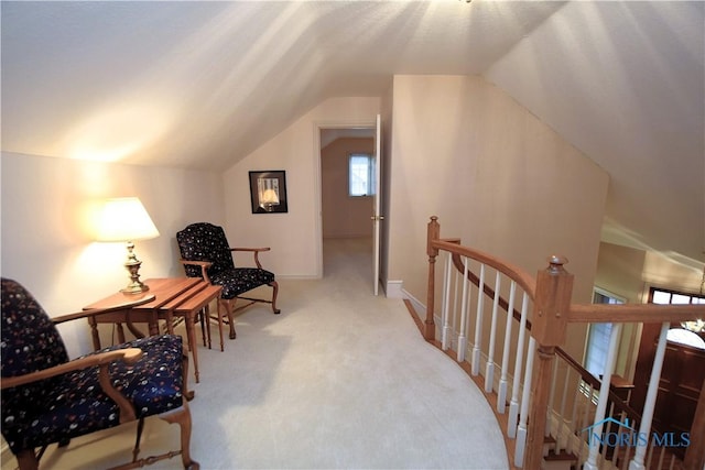 sitting room with carpet floors and vaulted ceiling