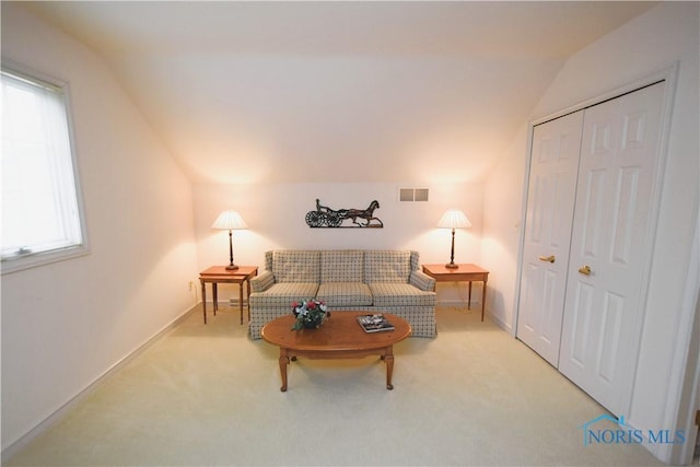 carpeted living room featuring plenty of natural light and lofted ceiling