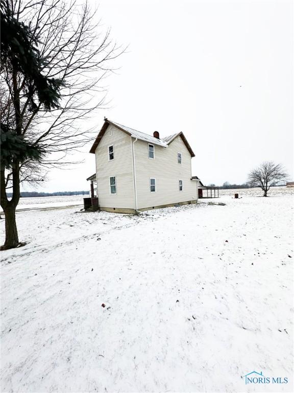 snow covered property with central AC unit