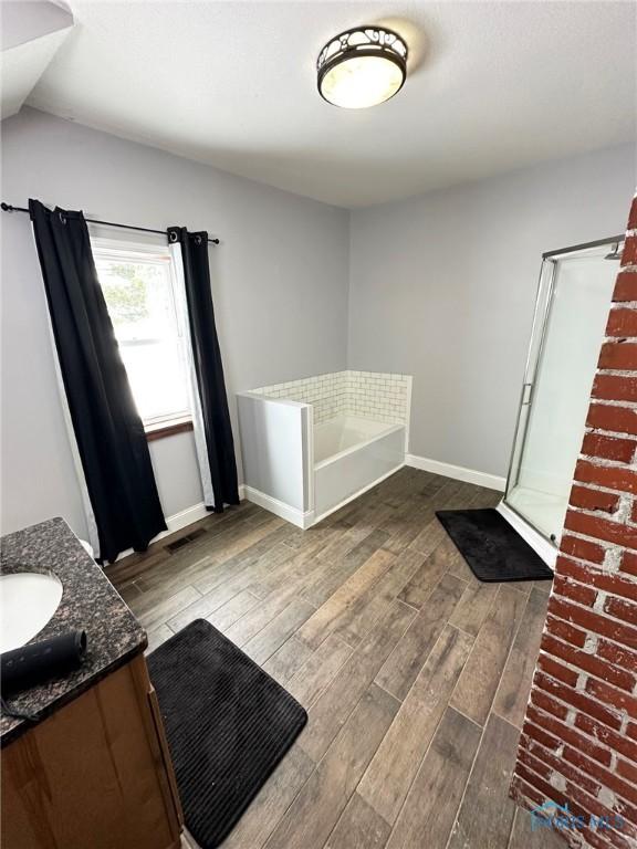 bathroom featuring shower with separate bathtub and vanity