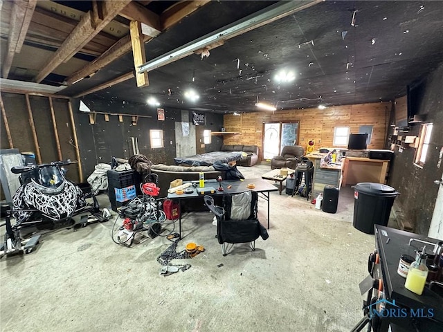 miscellaneous room with wooden walls and concrete floors