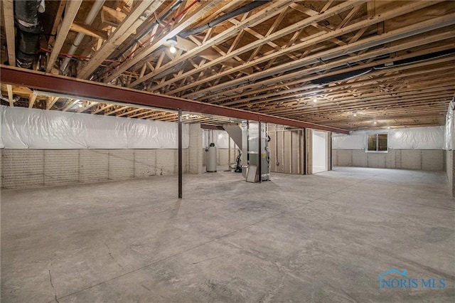 basement featuring brick wall, heating unit, and gas water heater