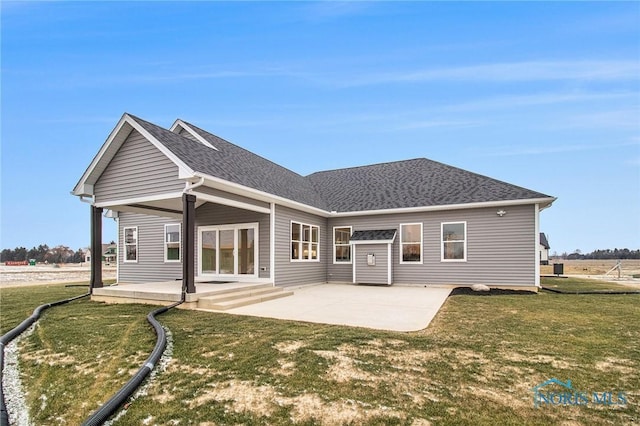 back of house with a lawn and a patio