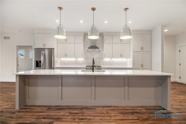 kitchen with hanging light fixtures, white cabinets, stainless steel appliances, and a large island