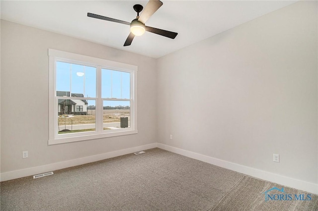 carpeted spare room featuring ceiling fan