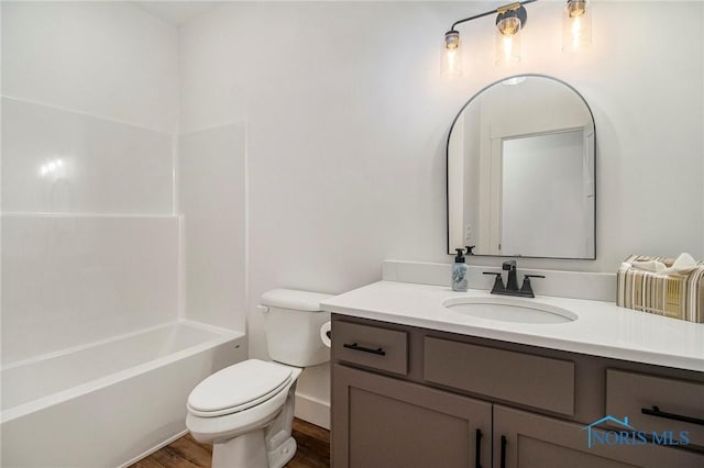 full bathroom featuring hardwood / wood-style flooring, shower / bath combination, toilet, and vanity